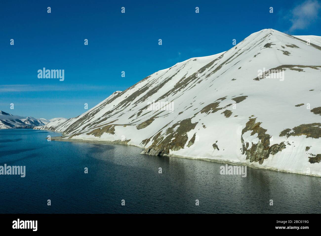 La côte montagneuse de la mer couverte de neige par un temps ensoleillé. Lieu de tournage sur la côte nord de la mer de Béring, région de Chukchi, Russie. Banque D'Images