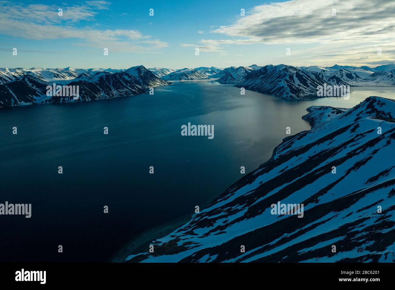 La côte montagneuse de la mer couverte de neige par un temps ensoleillé. Lieu de tournage sur la côte nord de la mer de Béring, région de Chukchi, Russie. Banque D'Images