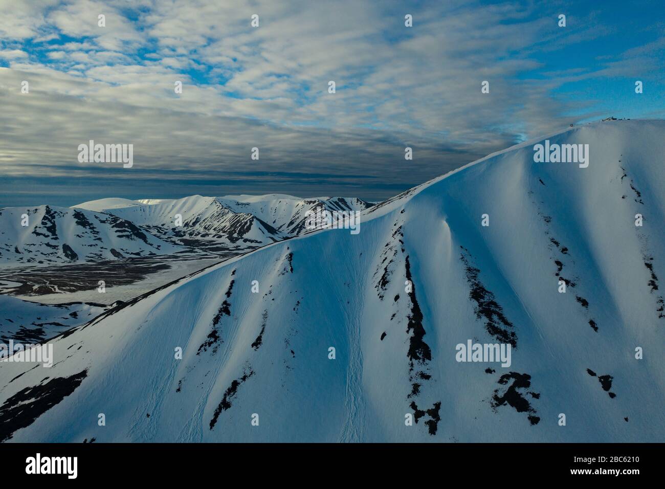 Les pentes des montagnes sont recouvertes de neige par temps nuageux. Lieu de tournage sur la côte nord de la mer de Béring, région de Chukchi, Russie. Banque D'Images