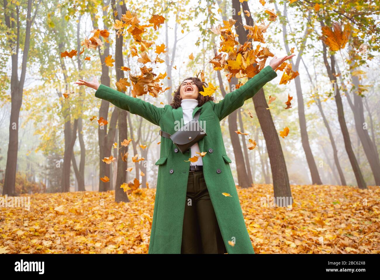 Une femme excitée s'amuser en photo de stock de forêt d'automne Banque D'Images