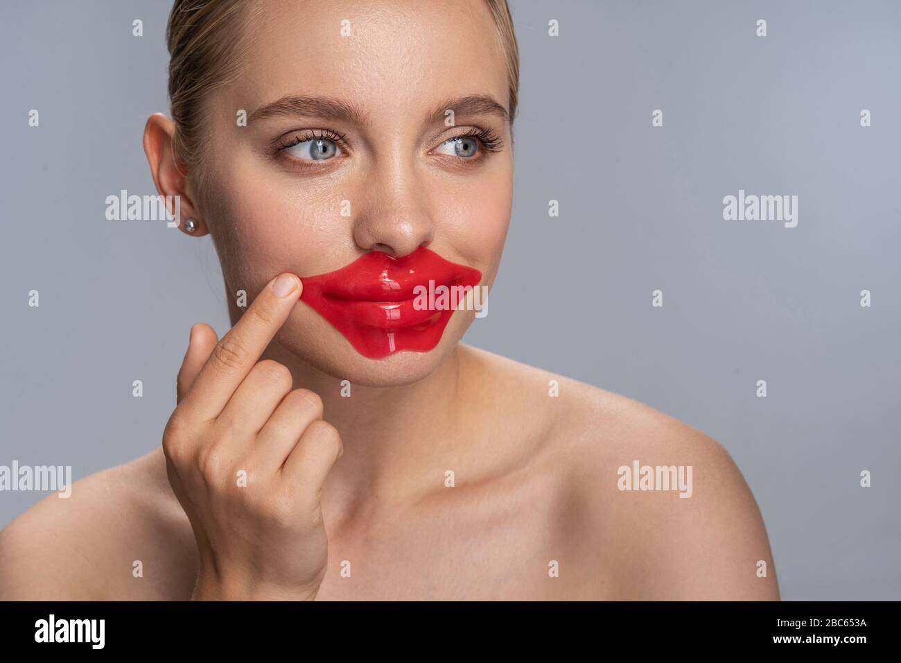 Jeune femme joyeuse qui teste des cosmétiques coréens Banque D'Images