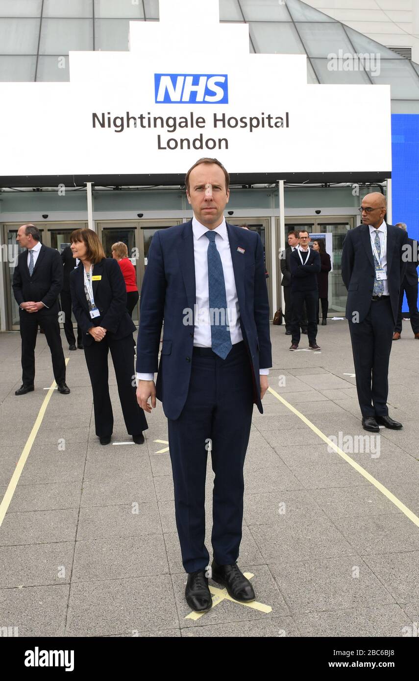 Le secrétaire à la santé Matt Hancock et le personnel du NHS se trouvent sur le terrain, mis en place pour s'assurer que les directives de distanciation sociale sont respectées, à l'ouverture de l'hôpital NHS Nightingale au centre Excel de Londres, Hôpital temporaire avec 4000 lits qui a été mis en place pour le traitement de Covid-19 patients. Banque D'Images