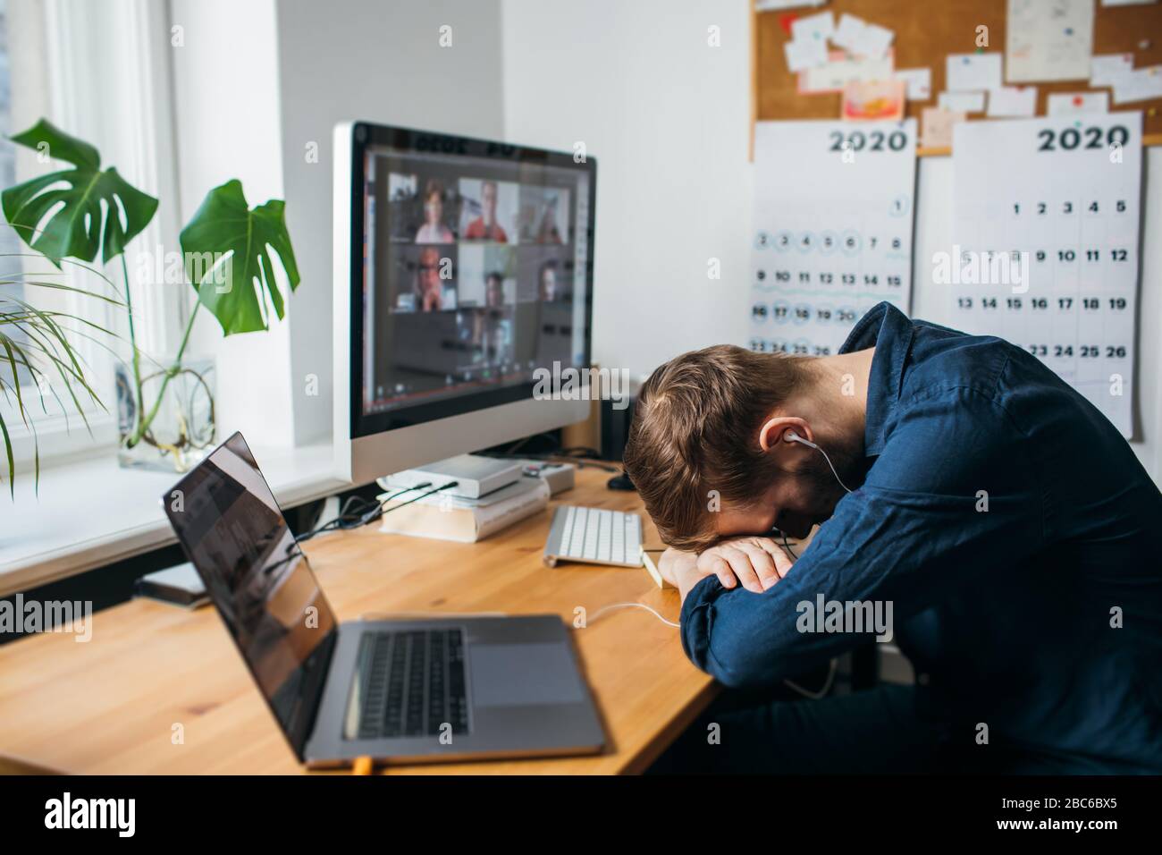 Homme d'affaires fatigué dormant sur son bureau tout en ayant un appel vidéo via un ordinateur dans le bureau à la maison. Restez à la maison et travaillez à partir du concept de la maison durin Banque D'Images
