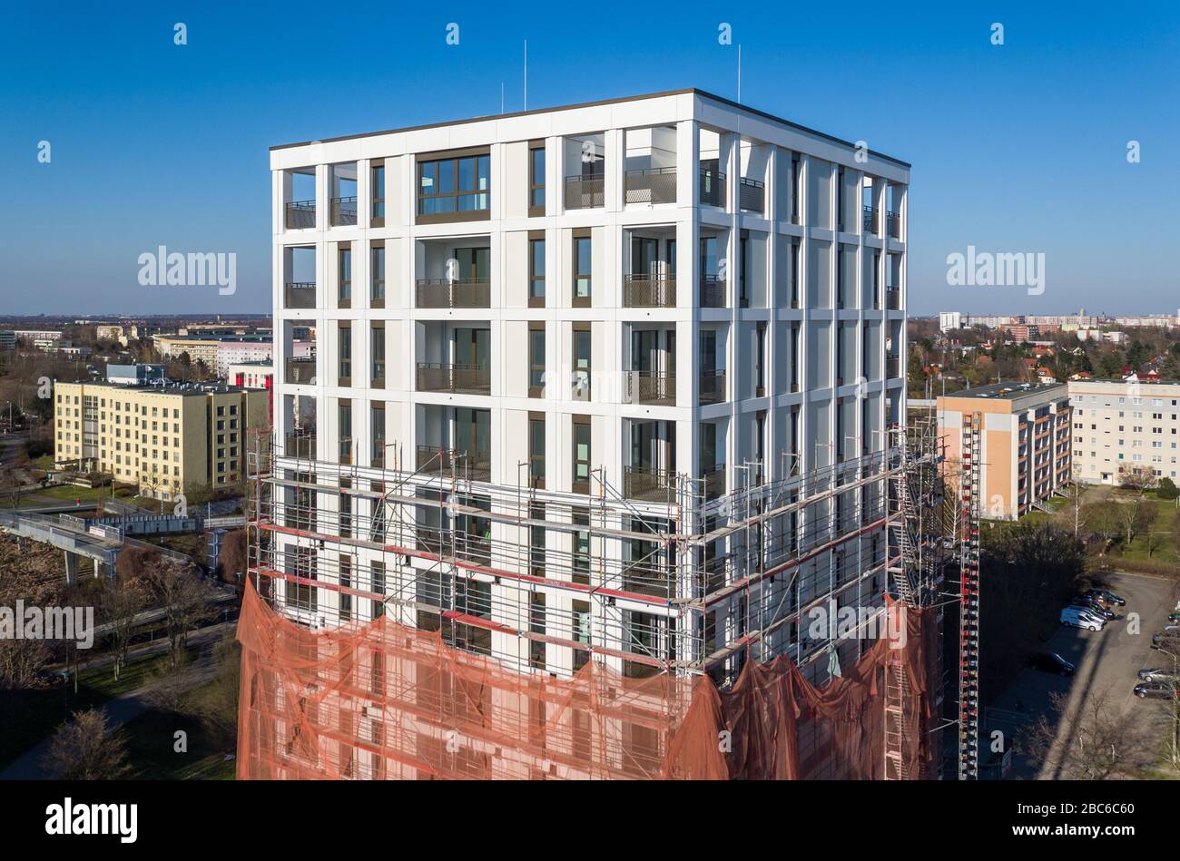 01 avril 2020, Saxe, Leipzig: Les échafaudages ont retiré les échafaudages du premier tiers de la nouvelle "Tour Lipsia". La première tour post-réunification dans le quartier de Granau, bâtiment en plaques de Leipzig, a une place pour 60 appartements sur ses 13 étages. La coopérative d'habitation Lipsia investit 13 millions d'euros. Le projet sans barrière 'Lipsia Tower' est principalement destiné aux locataires plus âgés. Selon les plans actuels, les premiers résidents devraient se déplacer en juillet. Les coopératives d'habitation saxonnes construisent 499 nouveaux appartements à l'échelle nationale en 2020. (Enregistré avec un drone) photo: J Banque D'Images