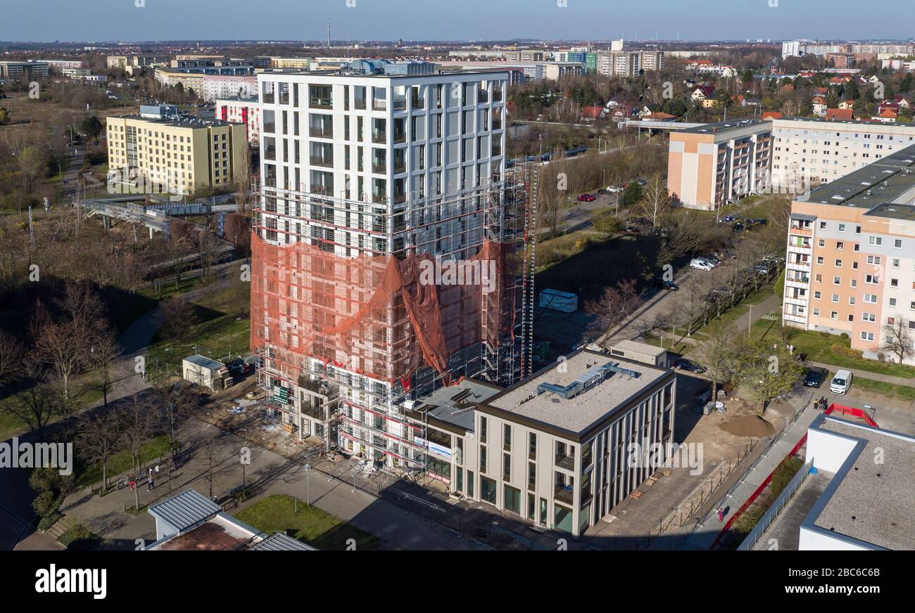 01 avril 2020, Saxe, Leipzig: Les échafaudages ont retiré les échafaudages du premier tiers de la nouvelle "Tour Lipsia". La première tour post-réunification dans le quartier de Granau, bâtiment en plaques de Leipzig, a une place pour 60 appartements sur ses 13 étages. La coopérative d'habitation Lipsia investit 13 millions d'euros. Le projet sans barrière 'Lipsia Tower' est principalement destiné aux locataires plus âgés. Selon les plans actuels, les premiers résidents devraient se déplacer en juillet. Les coopératives d'habitation saxonnes construisent 499 nouveaux appartements à l'échelle nationale en 2020. (Enregistré avec un drone) photo: J Banque D'Images