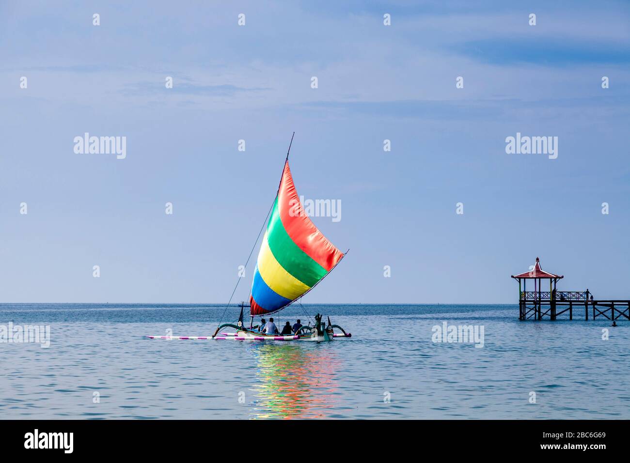 Les touristes qui prennent un bateau dans UN bateau à voile indonésien traditionnel (Jukung), près de Situbondo, Java, Indonésie Banque D'Images