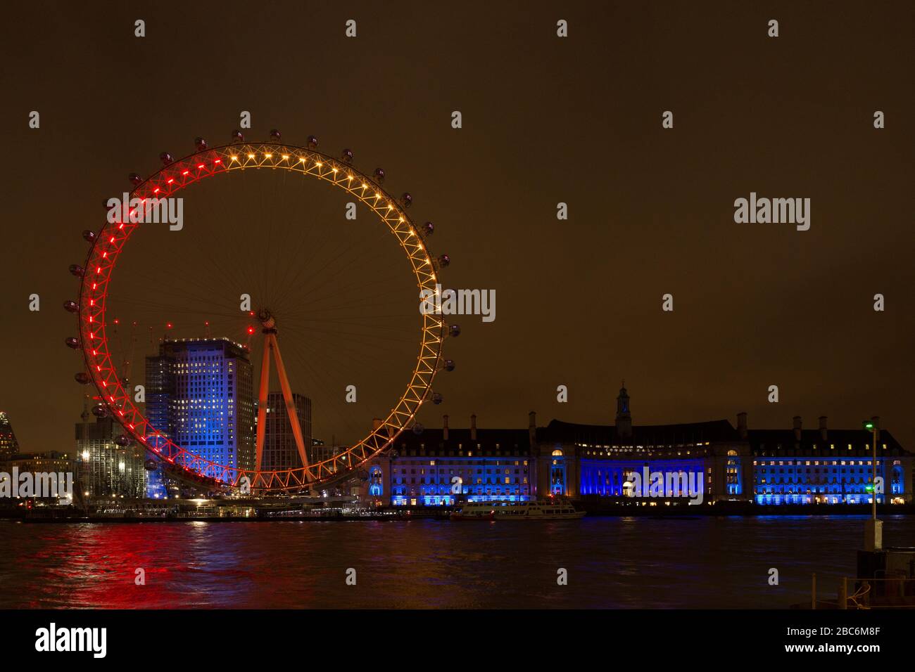 The London Eye, Millennium Eye la nuit devant County Hall. Illuminé dans le cadre de l'exposition d'art Lumiere London. Banque D'Images