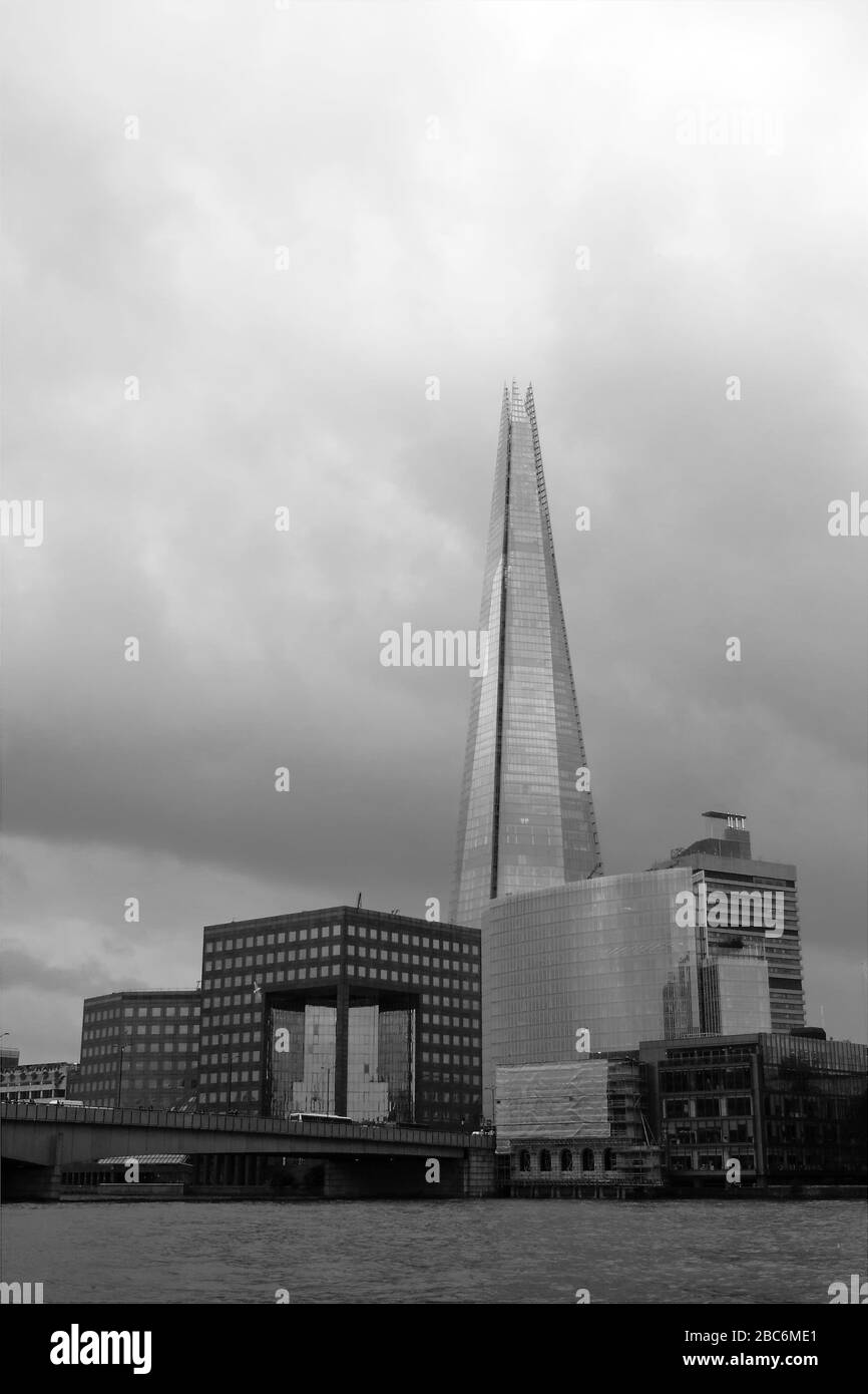 Une image monochrome regardant vers le Shard de l'autre côté de la Tamise avec le bâtiment supérieur postmoderniste n°1 London Bridge devant lui. Banque D'Images