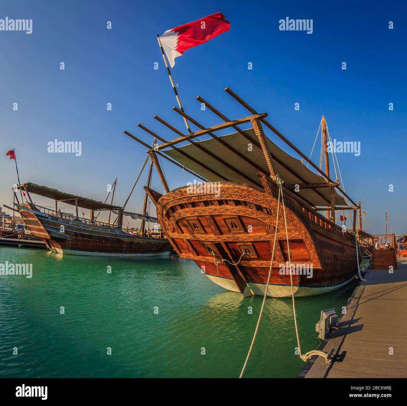 Bateaux en bois traditionnels (hurues) à Katara Beach Qatar vue de jour avec drapeau du Qatar et nuages dans le ciel Banque D'Images