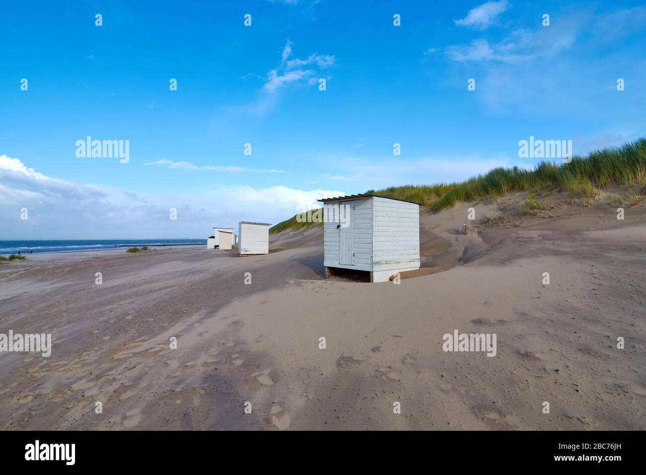 Petit casier blanc à la plage de la mer du Nord aux Pays-Bas. Le ciel bleu est intercalé de nuages. Banque D'Images