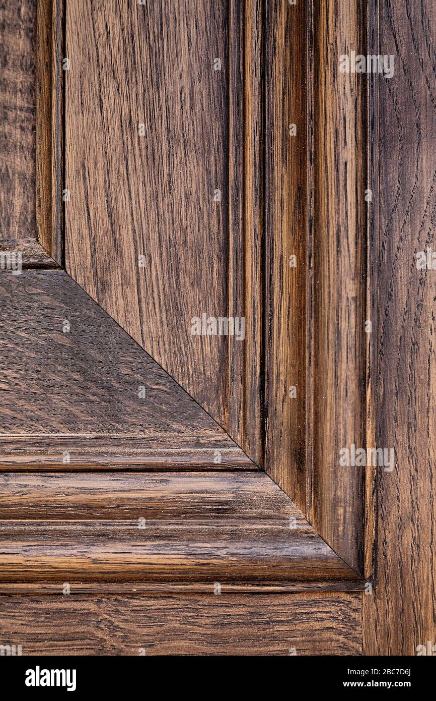 Gros plan droit sur une photo d'un détail de lambris et de grain de bois sur une porte en bois sombre Banque D'Images