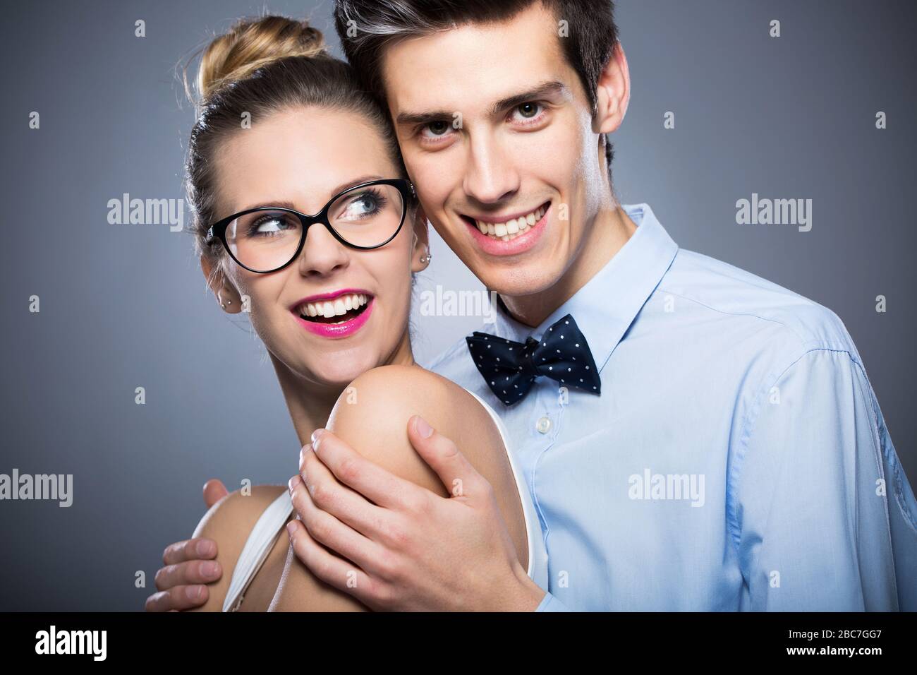 Jeune couple debout sur fond gris Banque D'Images