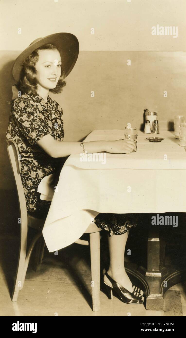 L'actrice américaine Virginia Gray montrant la position correcte à une table, USA 1940 Banque D'Images