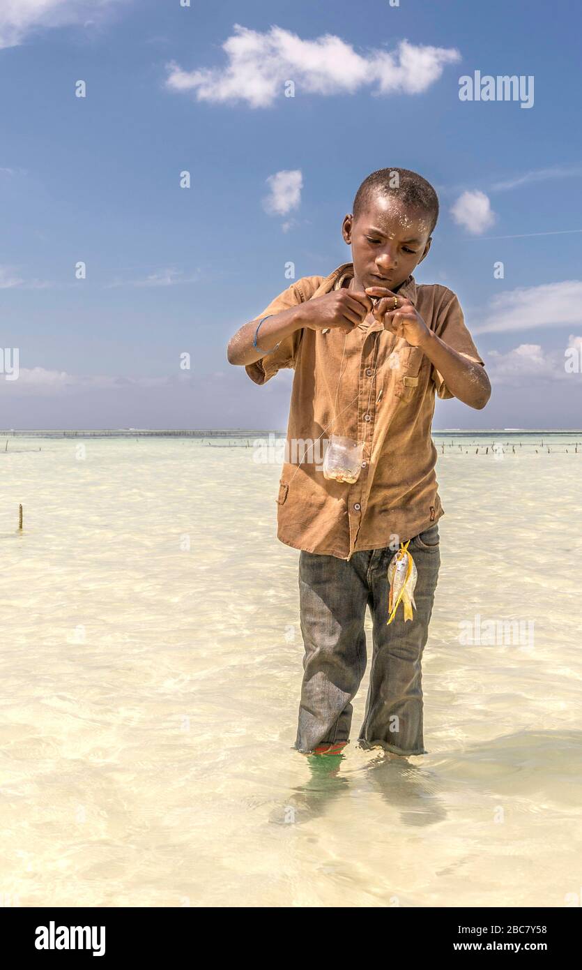 Jeune garçon attrapant du poisson dans la mer Banque D'Images