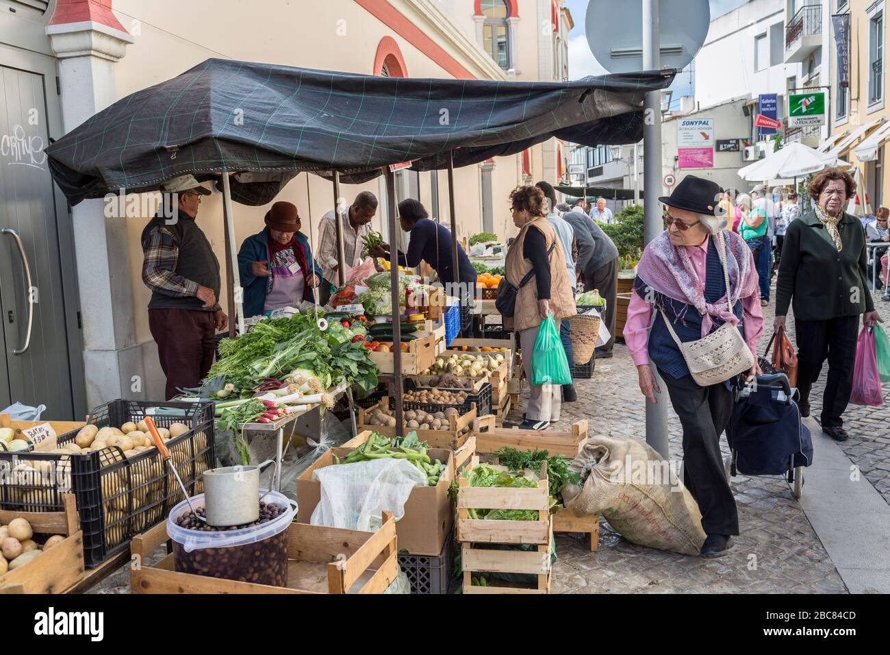 Homme marchant devant le marché des produits, Loule, Algarve, Portugal Banque D'Images