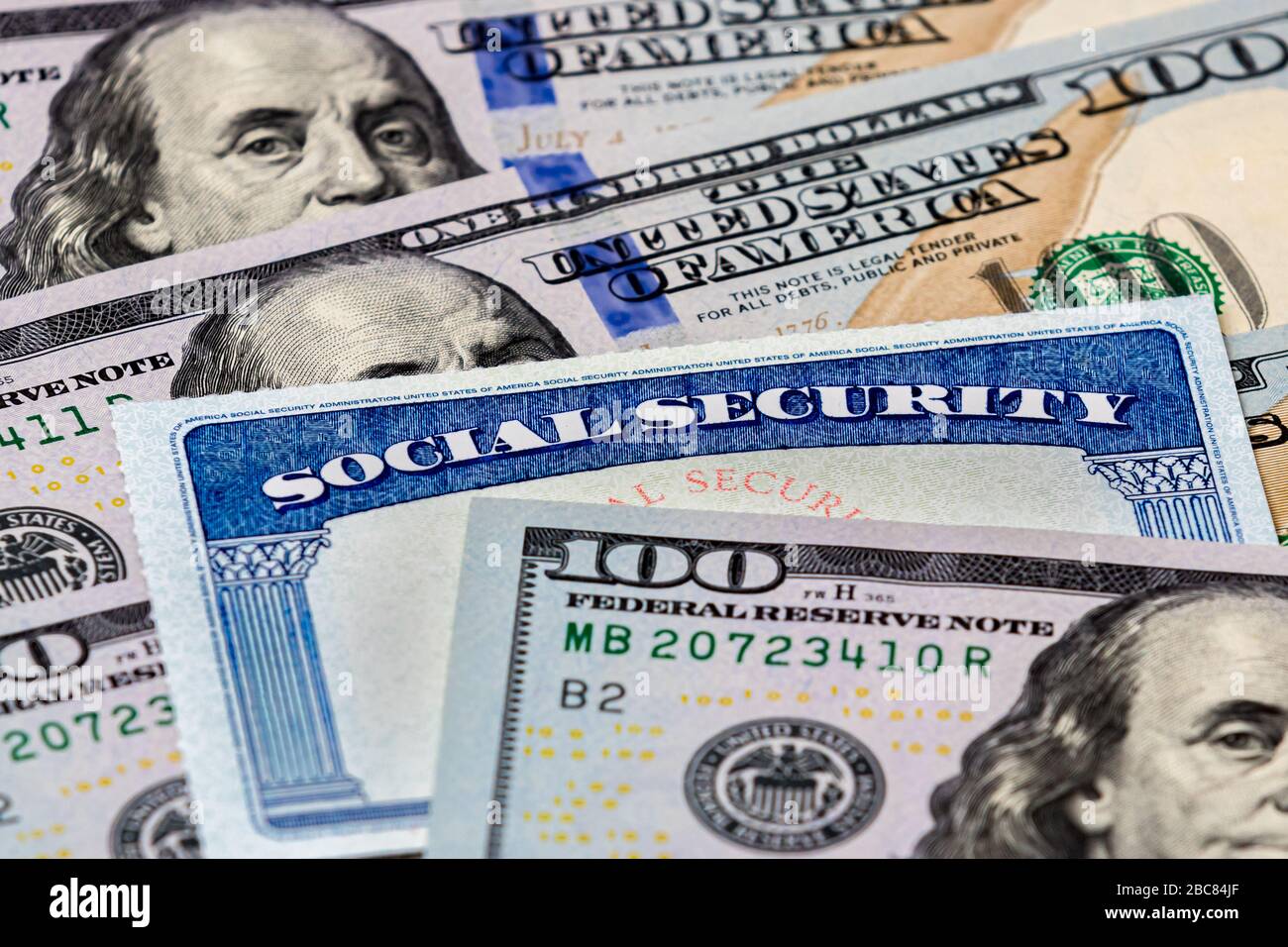 Gros plan de la carte d'identification des prestations de sécurité sociale avec des factures de 100 dollars Banque D'Images