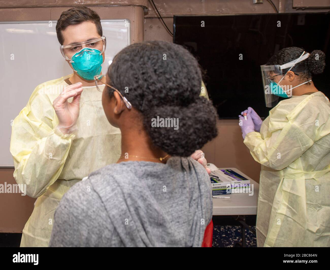 Hôpital de la marine américaine Corpsman 2ème classe Michael Lusk, prend un échantillon d'écouvillon pour les essais COVID-19 à bord du porte-avions USS Theodore Roosevelt le 1er avril 2020 dans le port d'Apra, à Guam. Le commandant des navires, le capitaine Brett Crozier, a été libéré de son devoir le 31 mars 2020 après avoir plaidé pour prendre des mesures pour enrayer la propagation des affaires COVID-19 sur son navire. Banque D'Images