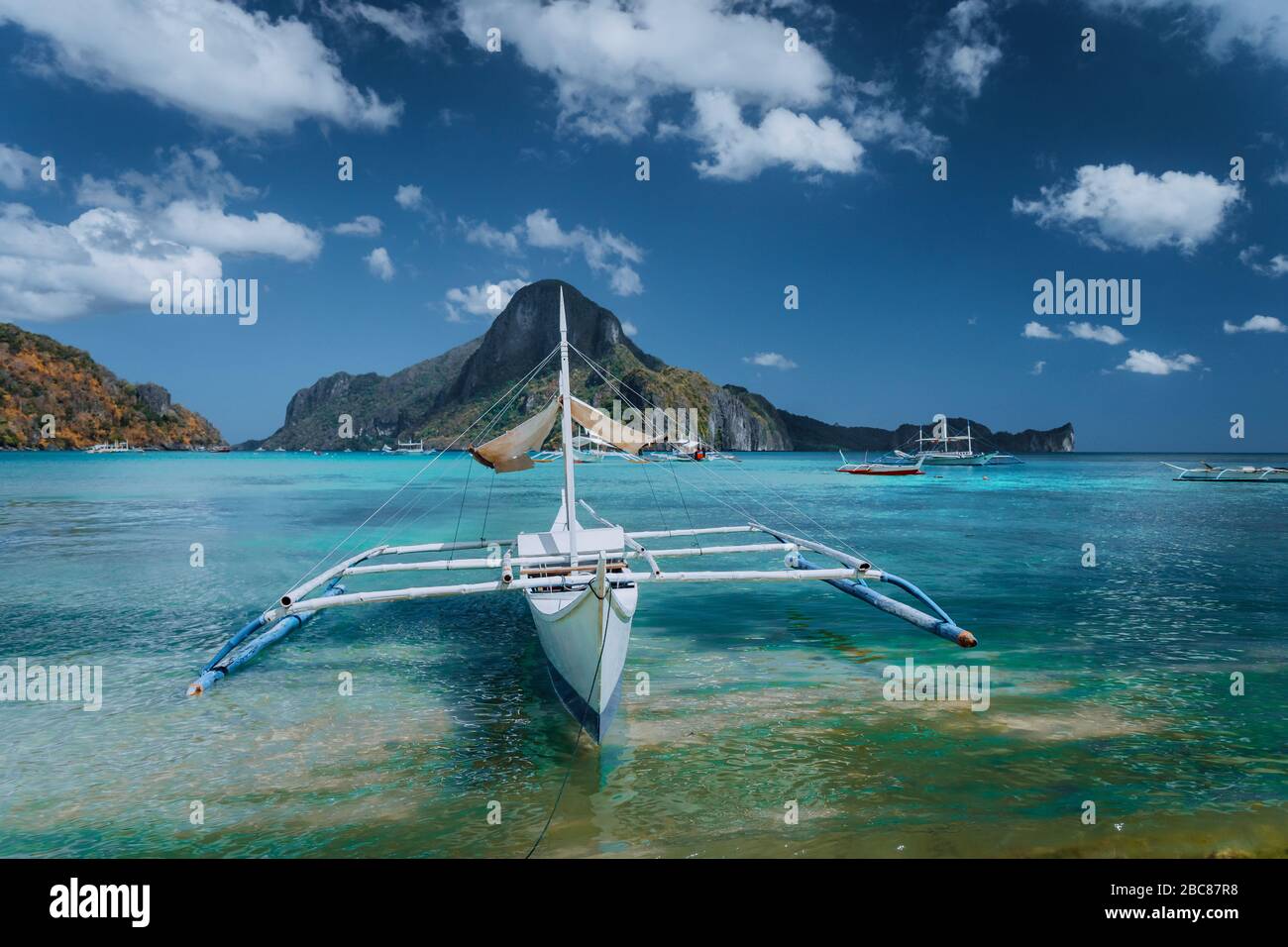 Panorama avec Cadlao filippino traditionnels banca bateau en avant. La baie de El Nido tropical exotique, l'île de Palawan, aux Philippines. Banque D'Images