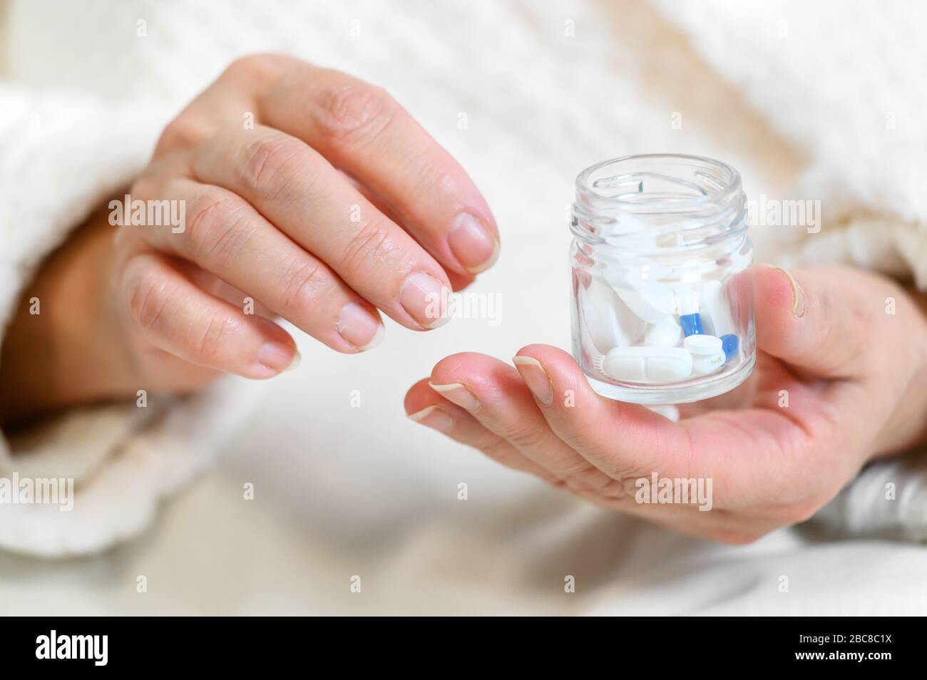 Femme âgée qui verse des pilules à partir de la bouteille à la main, vue rapprochée . Banque D'Images