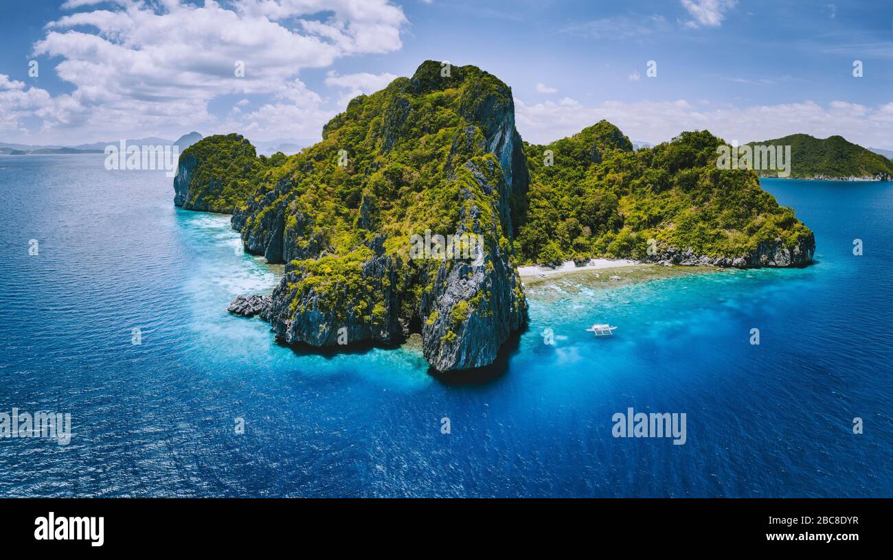 Drone aérien vue panoramique de tropical Paradise Island. Montagnes rocheuses calcaires karstiques entoure par blue ocean et de récifs coralliens. Banque D'Images Drone aérien vue panoramique de tropical Paradise Island. Montagnes rocheuses calcaires karstiques entoure par blue ocean et de récifs coralliens. Banque D'Images