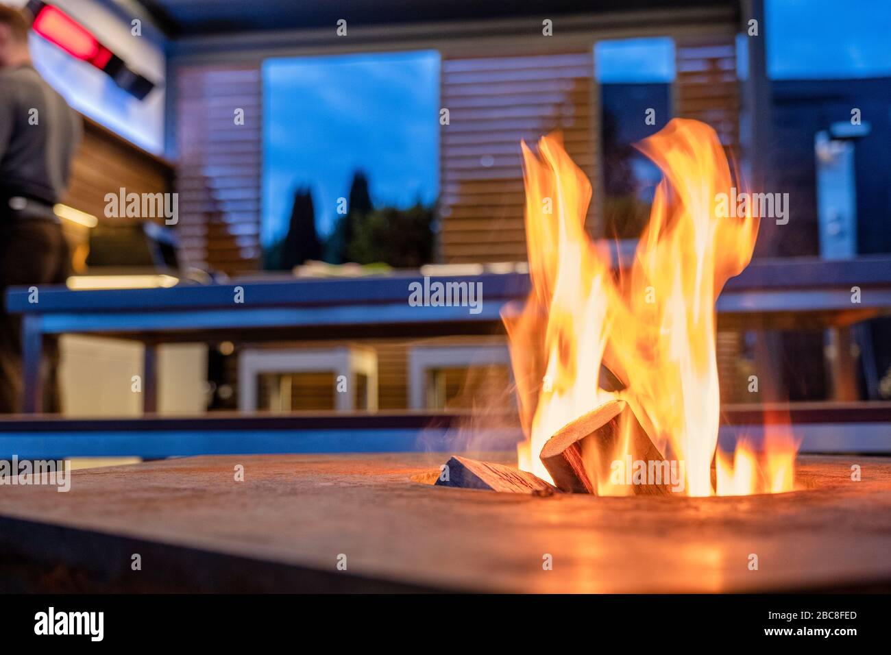 Ouvrez le feu dans une cuisine extérieure près d'une plaque de gril Banque D'Images