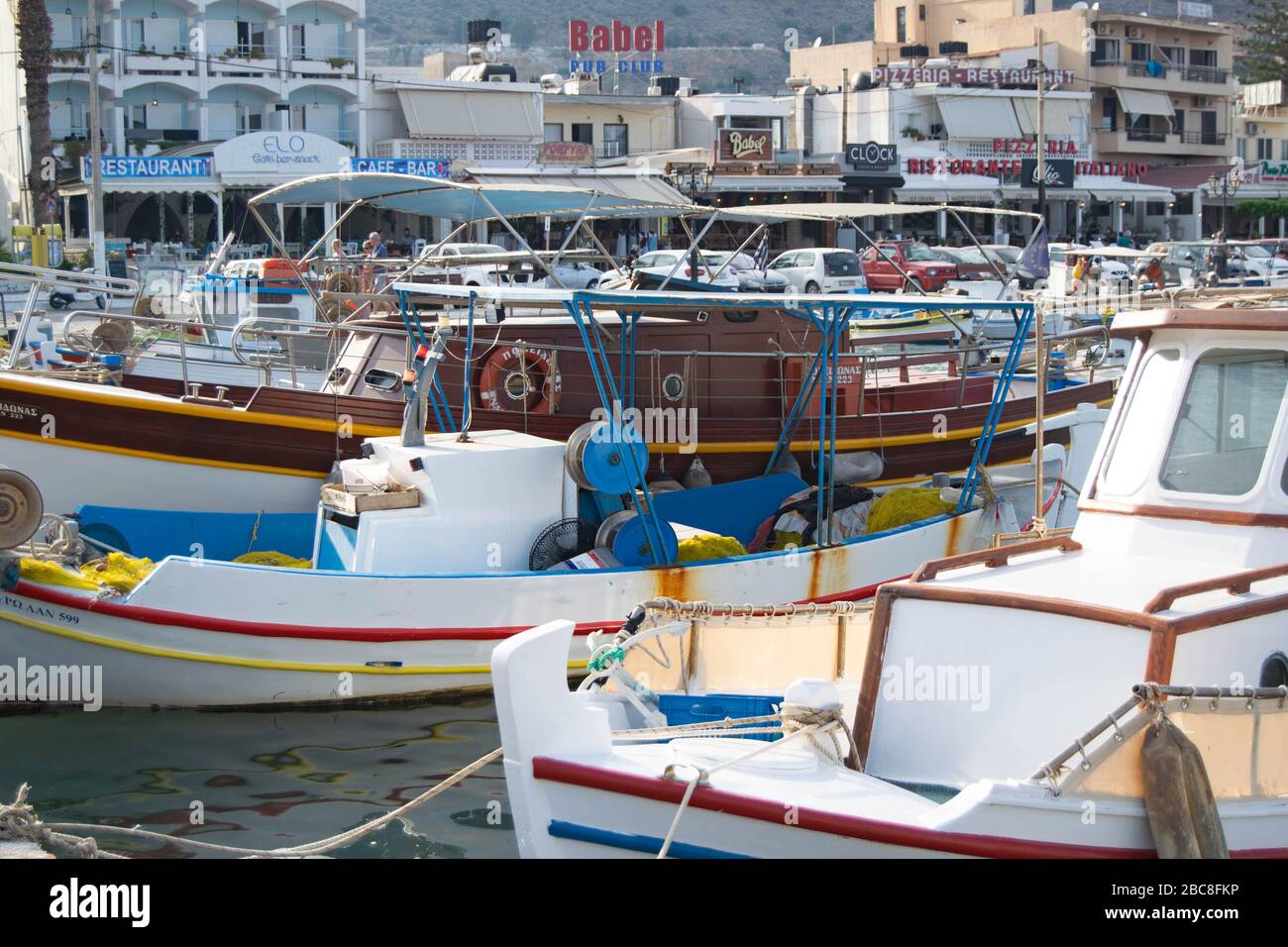 Petits bateaux aux couleurs vives dans une marina très animée de l'île grecque de Crète Banque D'Images