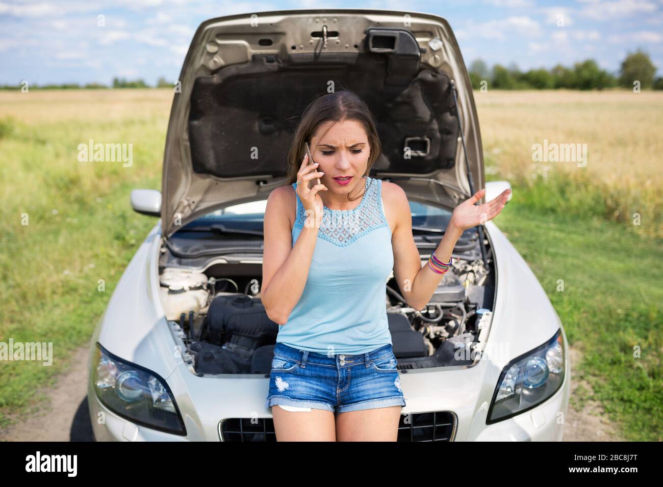 Femme avec une voiture en panne Banque D'Images