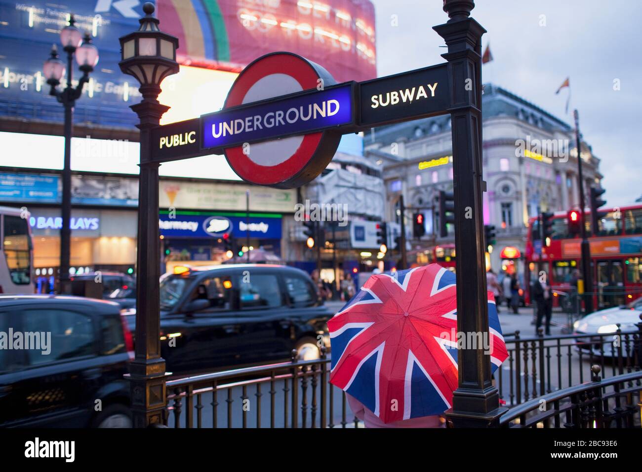 Personne tenant un parasol en entrant dans le métro, Piccadilly Circus, Londres, Angleterre, Royaume-Uni Banque D'Images