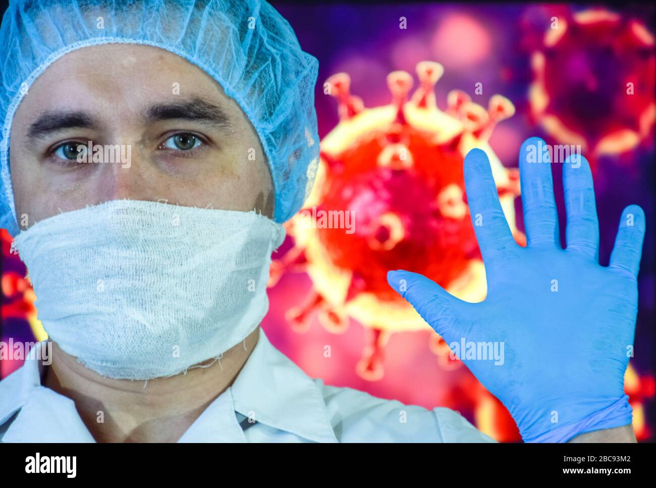 Un homme dans un masque et des gants de protection sur le fond de l'image d'un coronavirus. Médecin avec un vaccin et une seringue. Banque D'Images