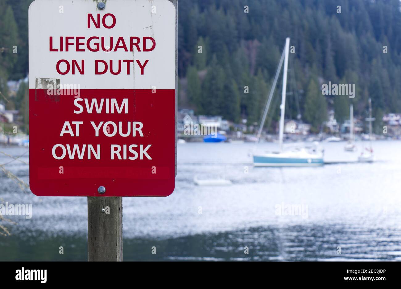 Un panneau avertit 'No Lifeguard on Duty', 'Wim at Your Own Risk' à Deep Cove, Canada Banque D'Images