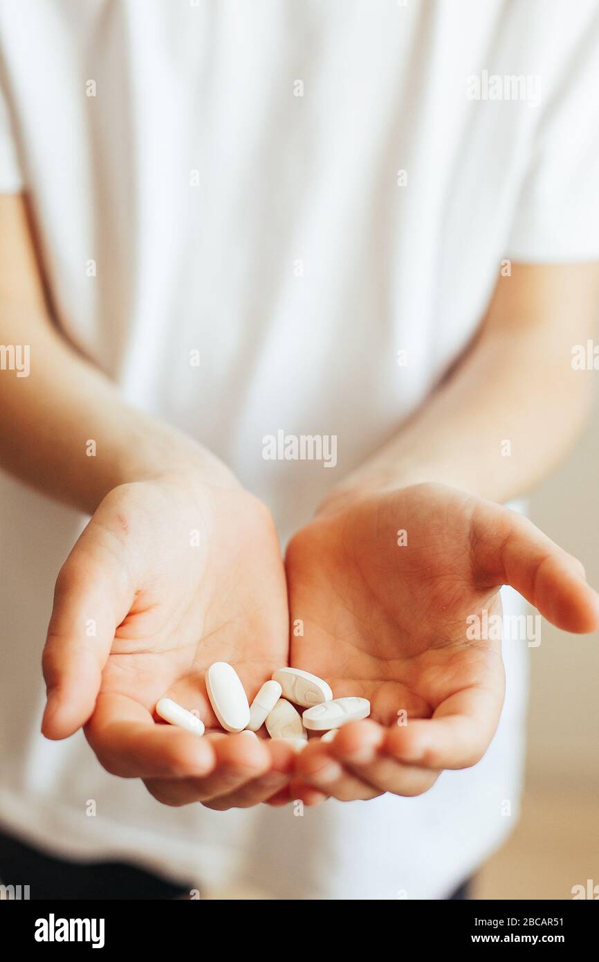 Gros plan des pilules de main. Main d'enfant avec pilules Banque D'Images