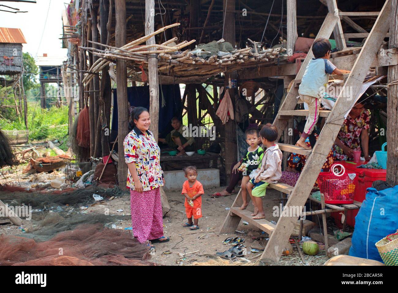 Famille cambodgienne devant leur maison dans le village de pêcheurs au Cambodge Banque D'Images