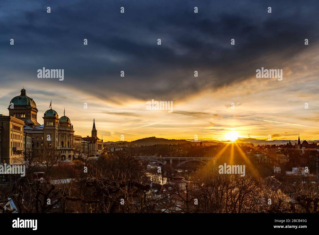 Un lever de soleil magique sous un ciel sombre illumine le Bundeshaus de Berne. Banque D'Images