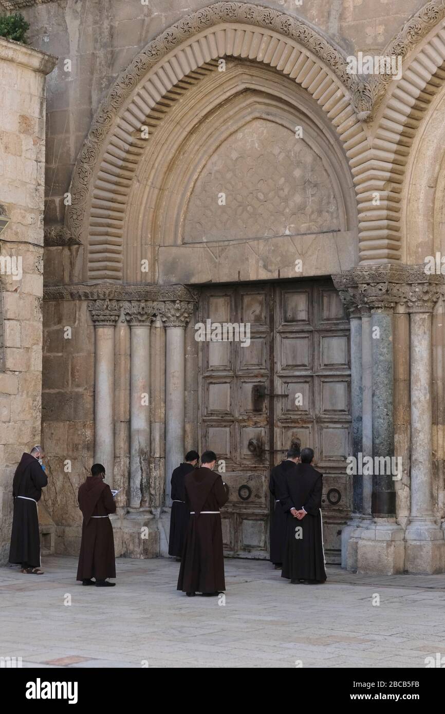 Jérusalem, Israël.3 avril 2020. Les moines franciscains prient devant l'entrée fermée de l'Église du Saint-Sépulcre dans la vieille ville de Jérusalem qui a été fermée comme mesure de contenir la propagation du nouveau coronavirus. Israël Banque D'Images