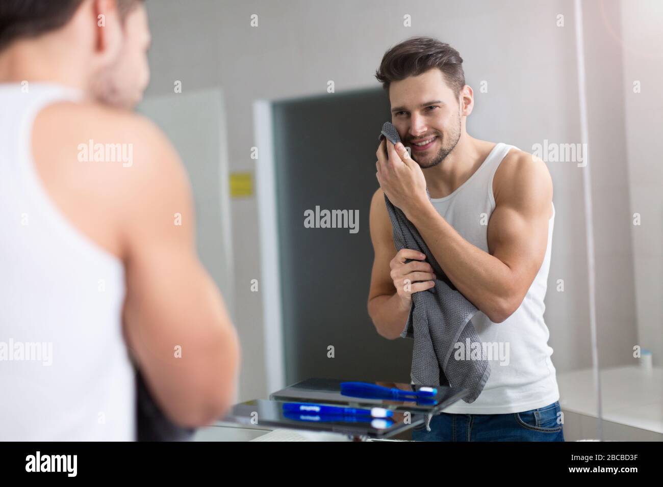 Jeune homme lave-visage dans salle de bains Banque D'Images