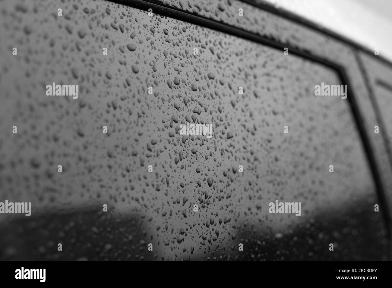 Verre de voiture humide avec cadre. Surface en verre noir avec gouttes de pluie. Texture naturelle des gouttes de pluie sur le verre, fond de fond pour le design Banque D'Images