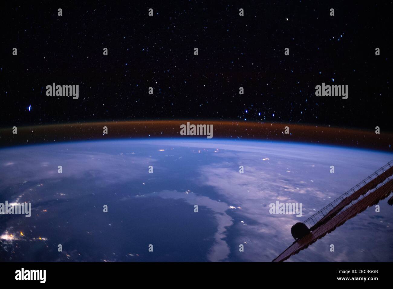 ISS - 4 mars 2020 - la teinte ambre plantant juste au-dessus du membre de la Terre est la lueur atmosphérique avec les étoiles de la voie lactée étincelant en arrière-plan Banque D'Images