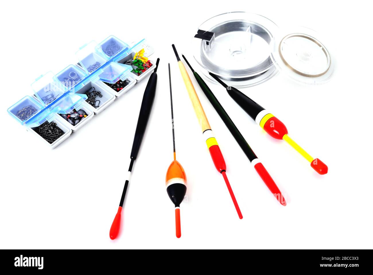 Boîte avec accessoires de pêche, flotteurs, ligne de pêche en bobines sur fond blanc gros plan Banque D'Images