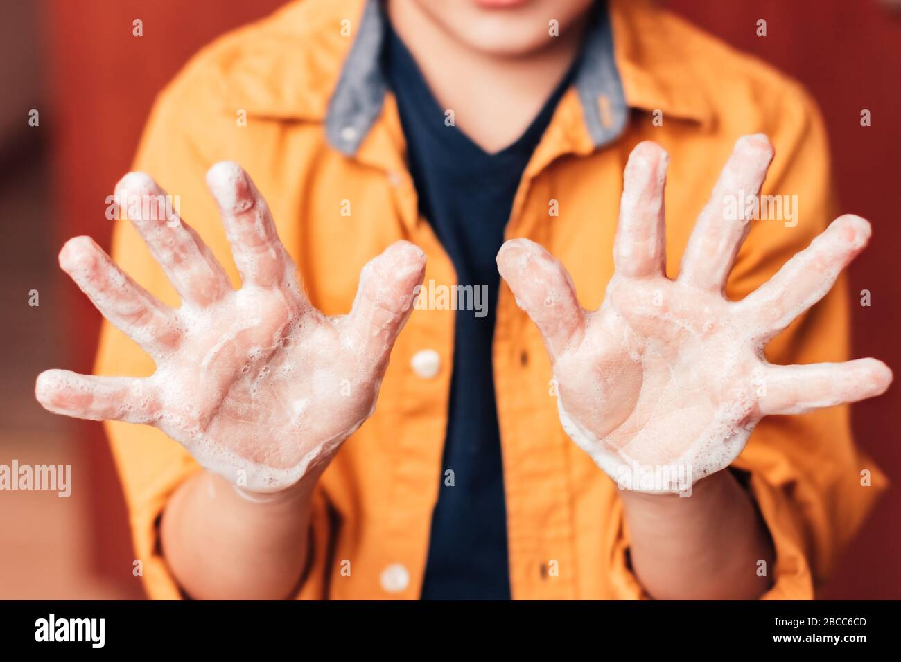 Vue avant des mains de bébés avec mousse de savon, concept d'hygiène personnelle Banque D'Images