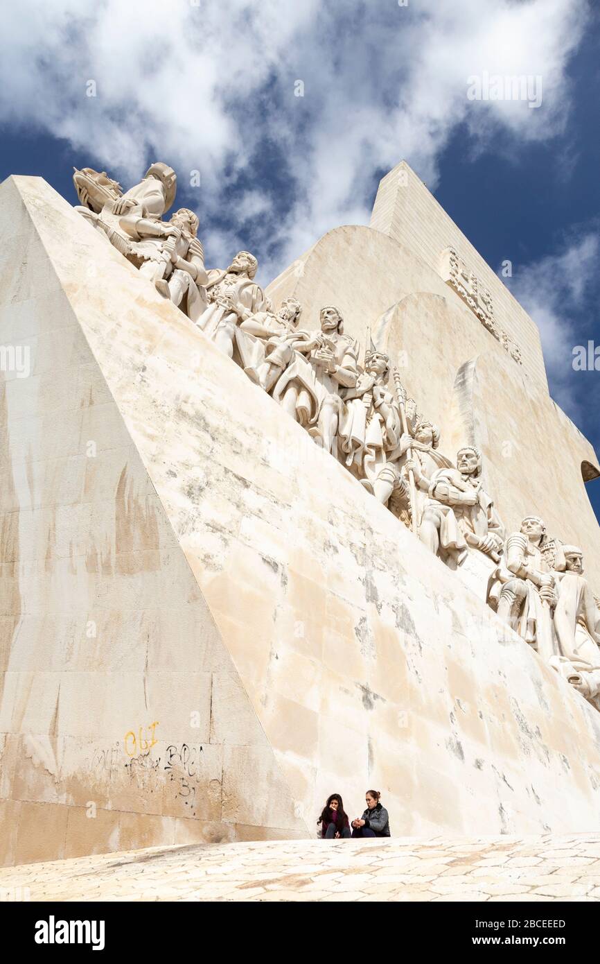 Vue à bas angle de deux touristes assis sous le Padrão dos Descobrimentos, Lisbonne Banque D'Images