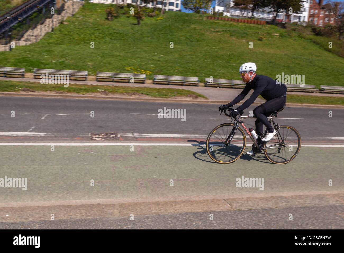 Southend-on-Sea, Royaume-Uni. 4 avril 2020. Un cycliste solitaire longe la piste cyclable désignée sur Western Esplanade, Southend-on-Sea, Essex, pendant le confinement COVID-19. La scène capture les infrastructures cyclables urbaines, la distanciation sociale et l’absence de circulation lors d’une chaude journée de printemps. Penelope Barritt/Alamy Live News Banque D'Images