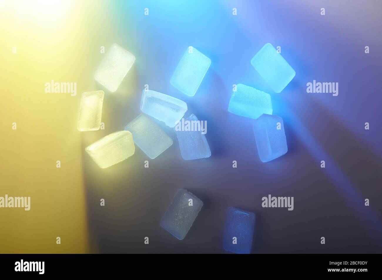 Glaçons sur fond bleu et jaune macro vue rapprochée Banque D'Images