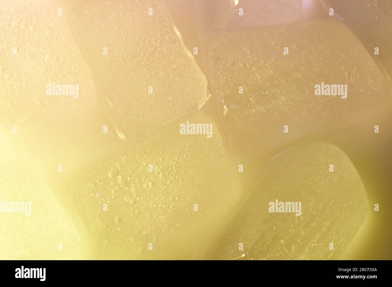 Glaçons jaunes congelés avec fond abstrait rose brillant Banque D'Images