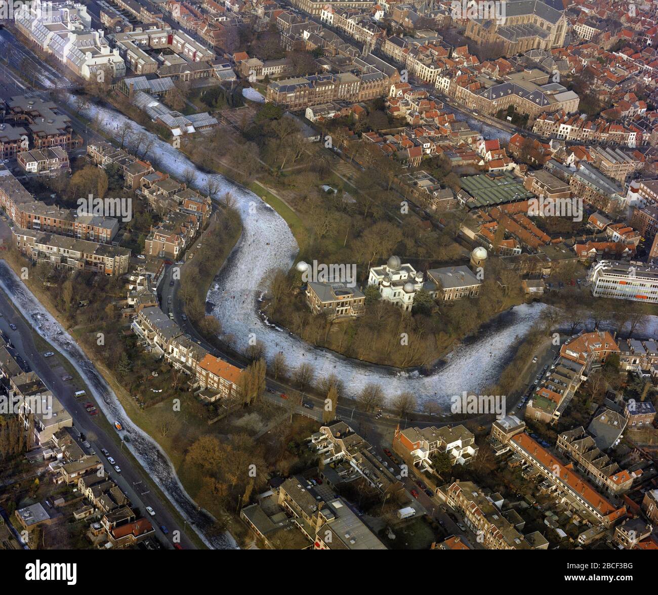 Leiden, Hollande, 10 février - 1986: Photo aérienne historique de Leiden, Hollande en hiver avec des gens patinant sur le canal gelé devant Leiden O Banque D'Images