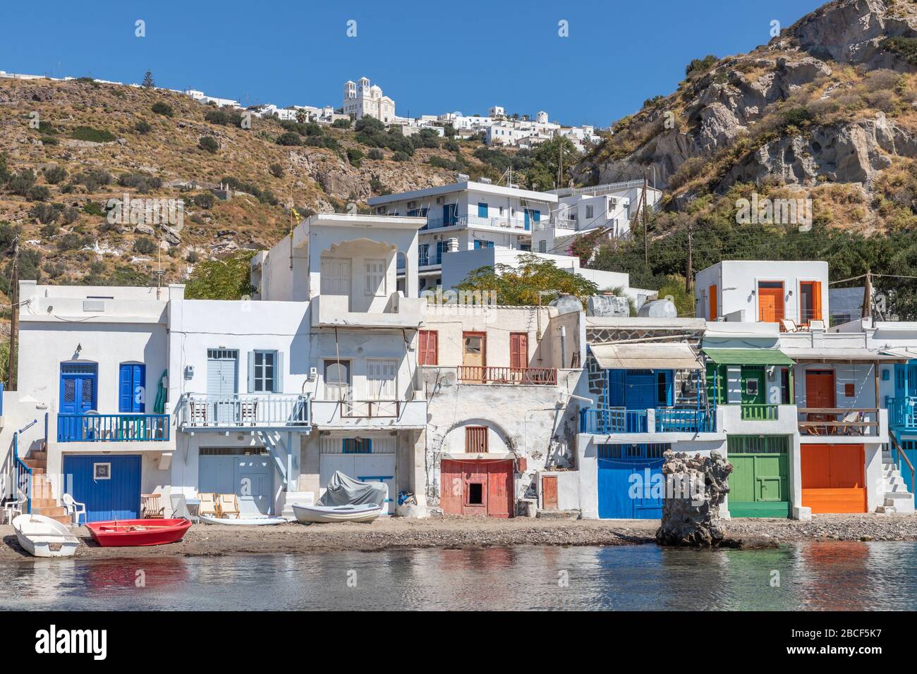 Maisons colorées de la plage de Klima avec le village de Trypiti en arrière-plan, Milos, Grèce Banque D'Images