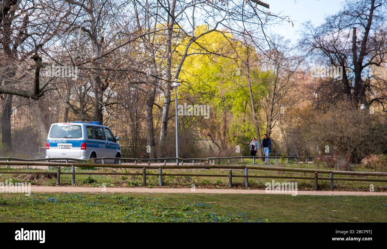 Une camionnette de police patrouille le parc Tiergarten dans le centre de Berlin pour faire respecter les règles de distanciation sociale pendant le confinement de la pandémie de corona, printemps 2020 Banque D'Images