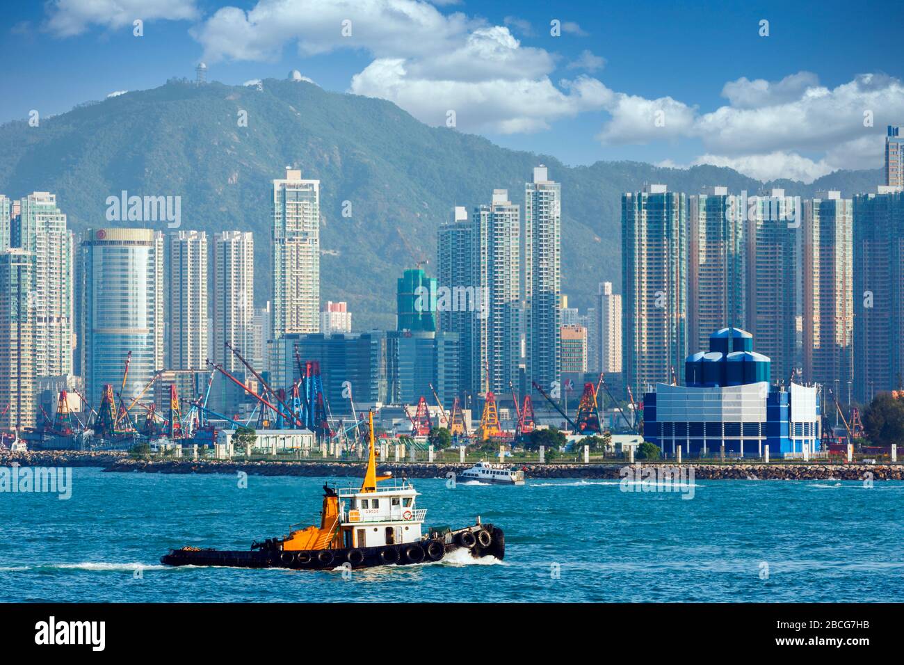 Hong Kong, Chine. Trafic d'eau sur le port de Victoria. Kowloon en arrière-plan. Banque D'Images