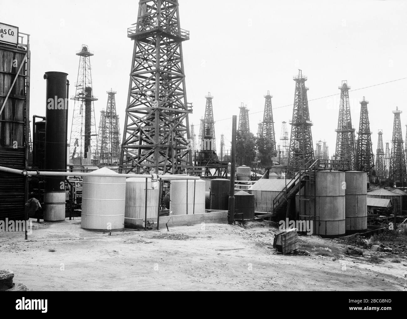 Derricks et réservoirs de stockage dans un champ de pétrole de long Beach, Californie, années 1920. Photographie par Burton Holmes. Banque D'Images
