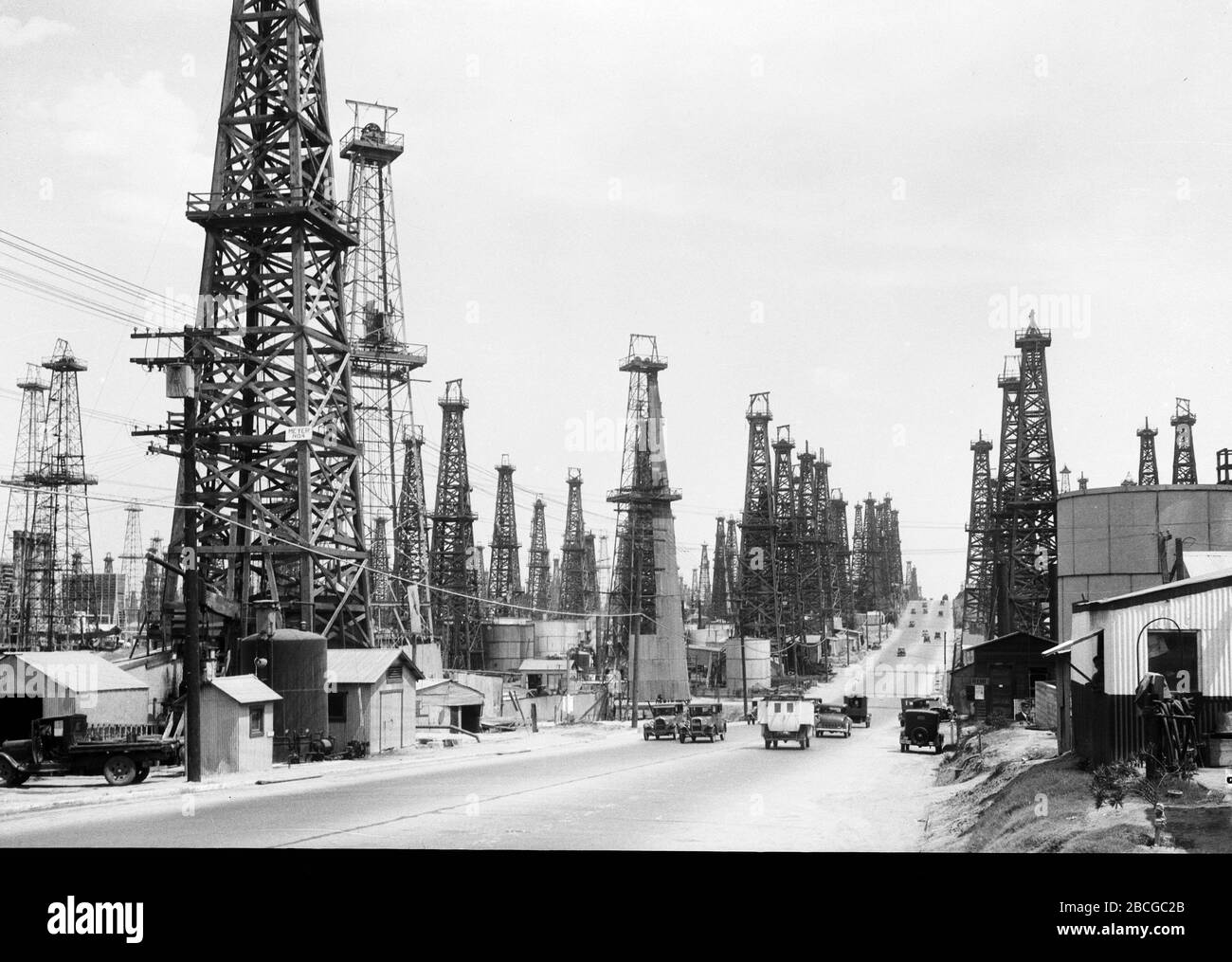 Derricks à l'huile près d'une route à long Beach, Californie, années 1920. Photographie par Burton Holmes. Banque D'Images