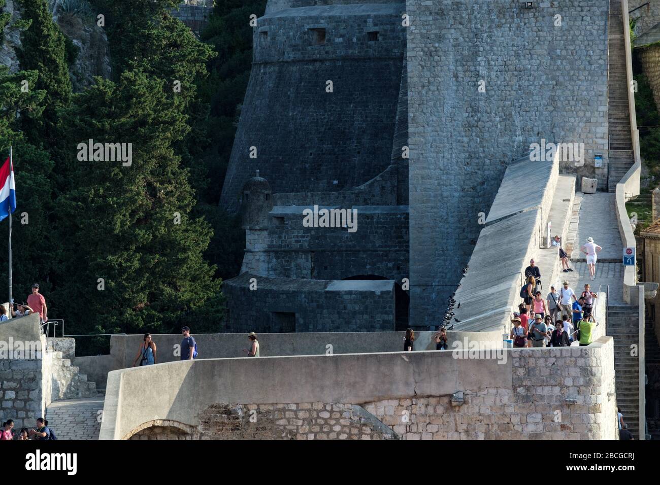 Les touristes marchant autour des murs de la ville à l'extérieur de la vieille ville de Dubrovnik, Croatie Banque D'Images